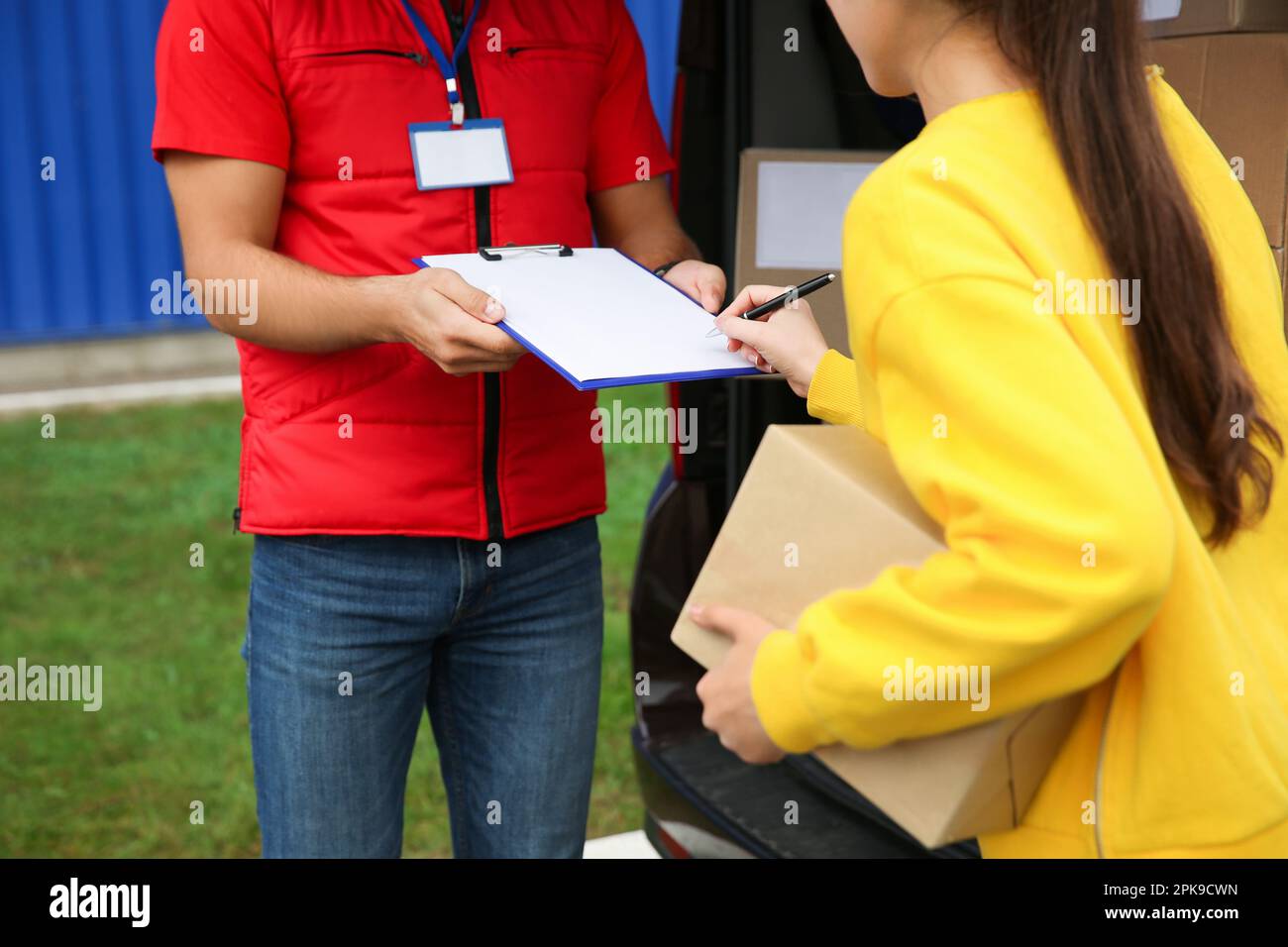 Courier receiving receipt signature from customer outdoors, closeup ...