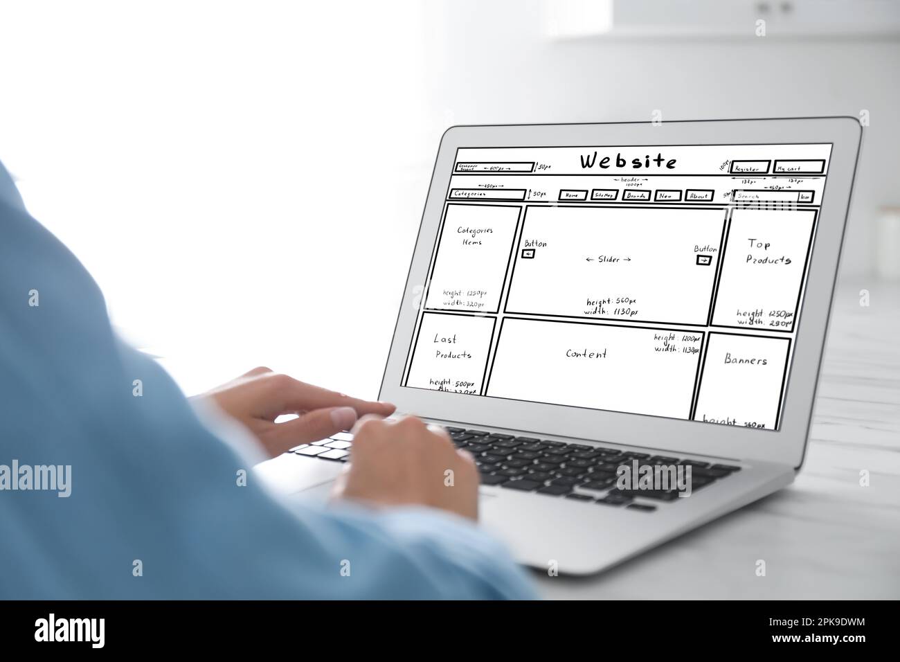 Designer creating website on laptop at white table, closeup Stock Photo