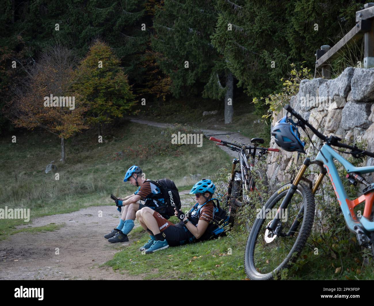 Small break: mountain bikers on the side of the path between Lac des Truites and Lac Vert Stock Photo