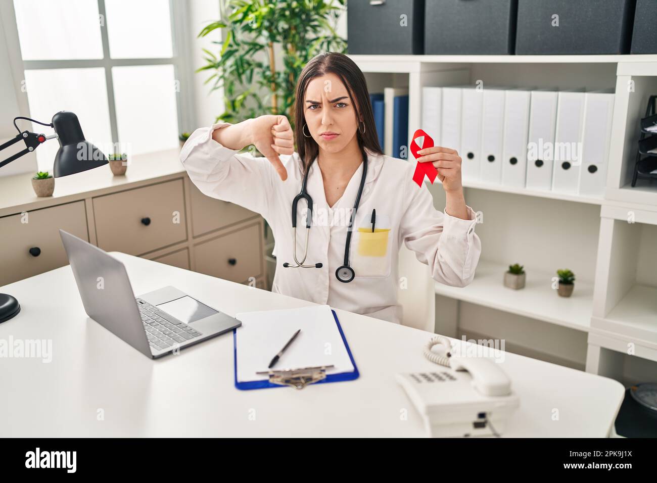 Hispanic doctor woman holding support red ribbon with angry face ...