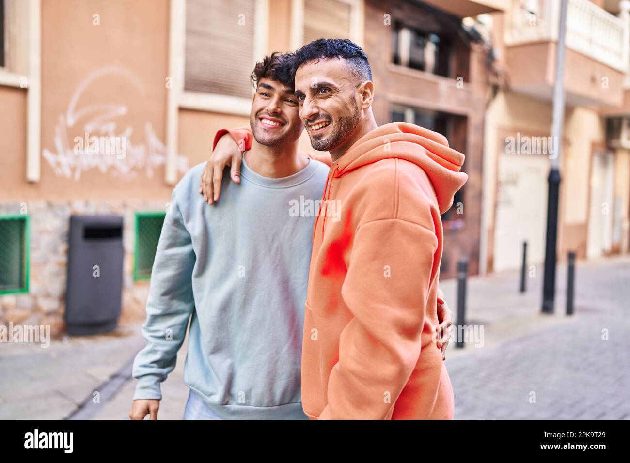 Two man couple hugging each other standing at street Stock Photo - Alamy