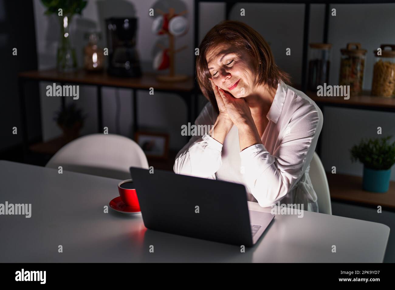 Middle age hispanic woman using laptop at home at night sleeping tired ...