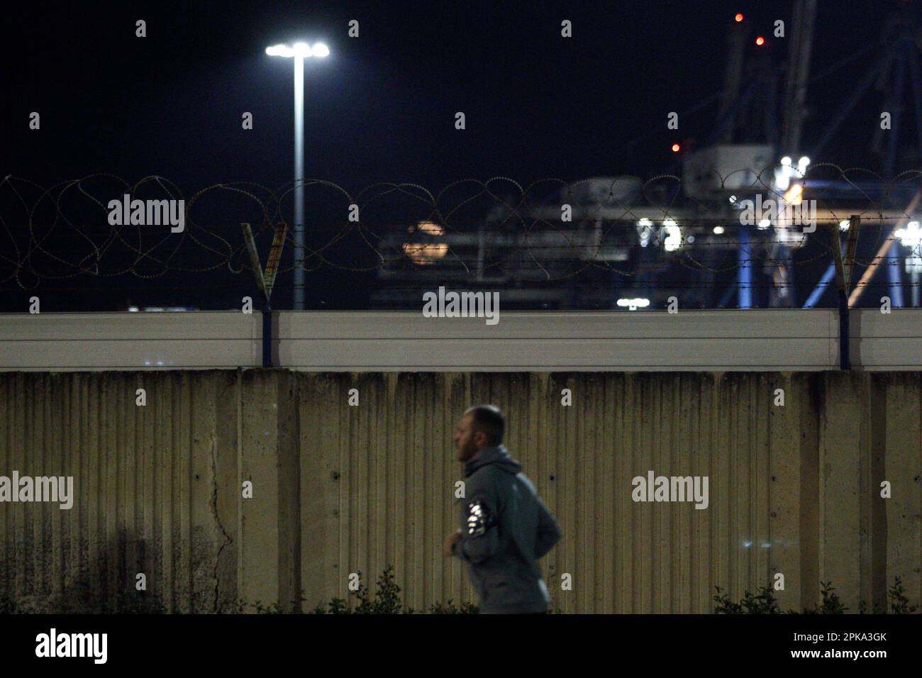 Limassol, Cyprus. 06th Apr, 2023. A man is seen running while the Pink Full Moon is rising above the port of Limassol on Apr. 6, 2023. The pink moon gets its name from a hot pink wildflower, Phlox subulata, that grows in a thick mat of vibrant foliage, commonly referred to as creeping phlox, moss phlox or moss pink. (Photo Kostas Pikoulas/SIPA USA). Credit: Sipa USA/Alamy Live News Stock Photo