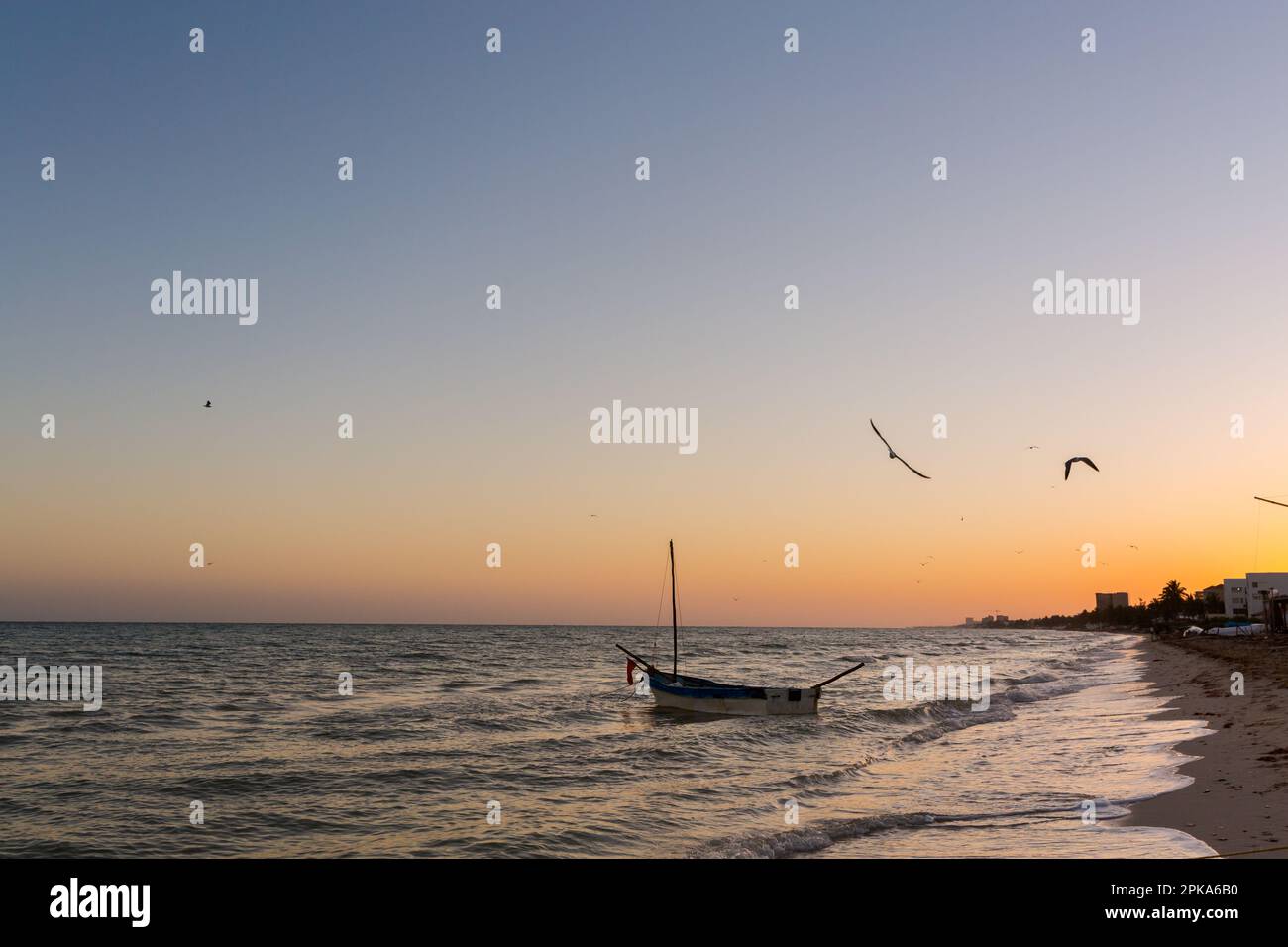 Beautiful Progreso beach in Mexico during sunset. Romantic white beach and a boat in the sea Stock Photo