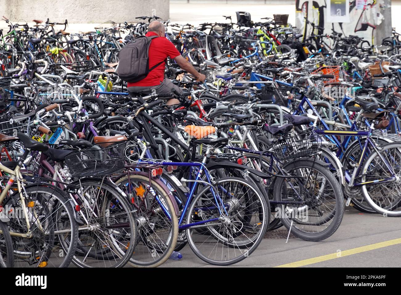 19.05.2022, Switzerland, Canton of Zurich, Zuerich - Man driving over a full bicycle car park. 00S220519D153CAROEX.JPG [MODEL RELEASE: NO, PROPERTY RE Stock Photo