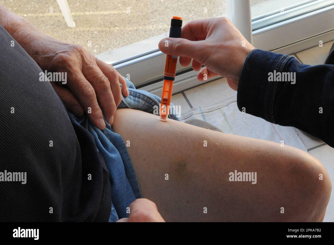 Liberal campaign nurse at the home of a diabetic patient for blood sugar testing by transdermal patch scan and slow insulin injection. Stock Photo