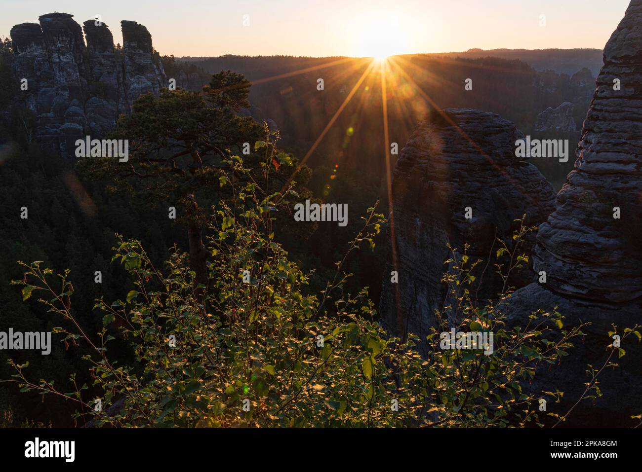 Elbe Sandstone Mountains Saxon Switzerland: Impressions during sunrise. Locomotive with sun star, backlight shot Stock Photo