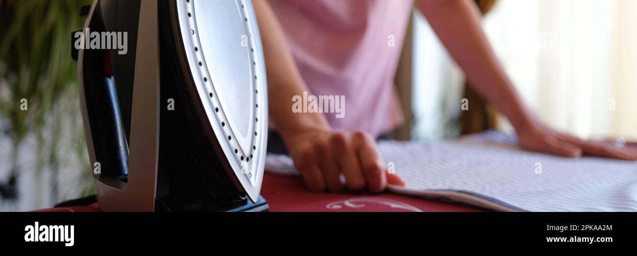 Closeup of housewife preparing bed linen on board for ironing. Woman
