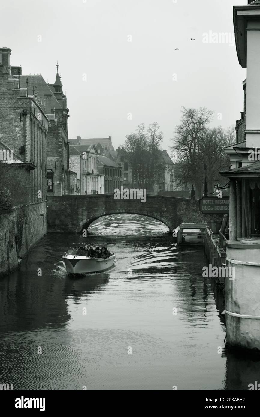 A tourist boat negotiates the Blinde-Ezelbrug on the Groenerei canal, Brugge, Belgium Stock Photo