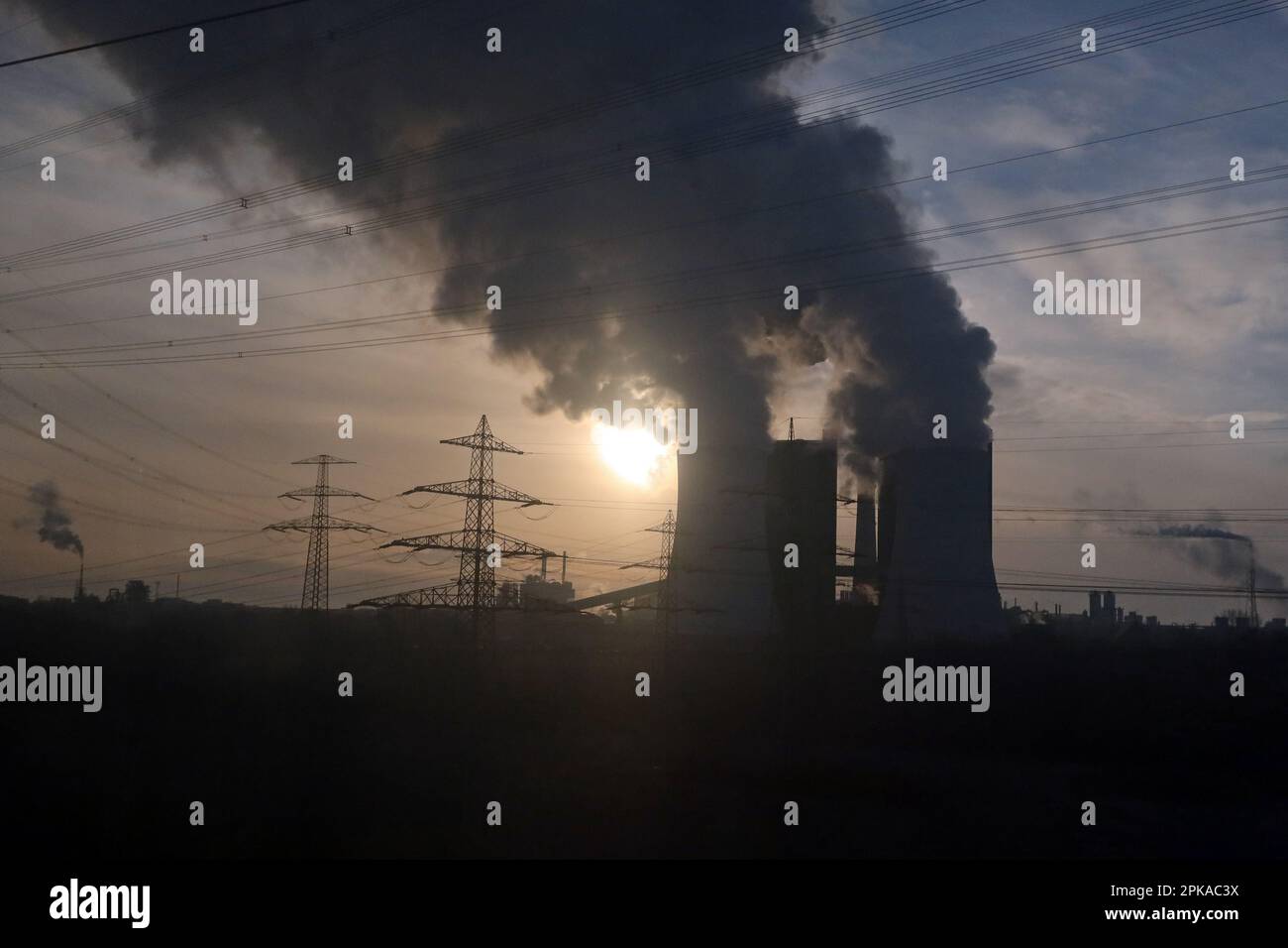 20.01.2023, Germany, Saxony-Anhalt, Schkopau - Smoking chimneys of the lignite-fired power plant Schkopau in the backlight of the sun. 00S230120D667CA Stock Photo