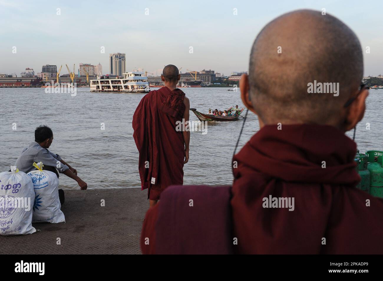 22.11.2013, Myanmar, , Yangon - Buddhist monks wait for ferries and river taxis on the southern bank of the Yangon River, while the former capital's b Stock Photo