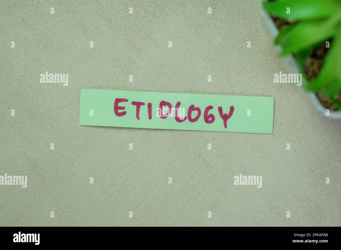 Concept of Etiology write on sticky notes isolated on Wooden Table. Stock Photo