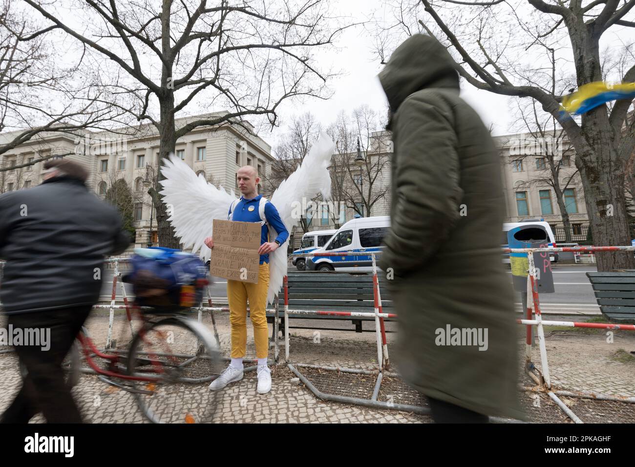 24.02.2023, Germany, Berlin, Berlin - Demonstrator with large angel wings protests in front of the Russian embassy. In his hands he holds a cardboard Stock Photo
