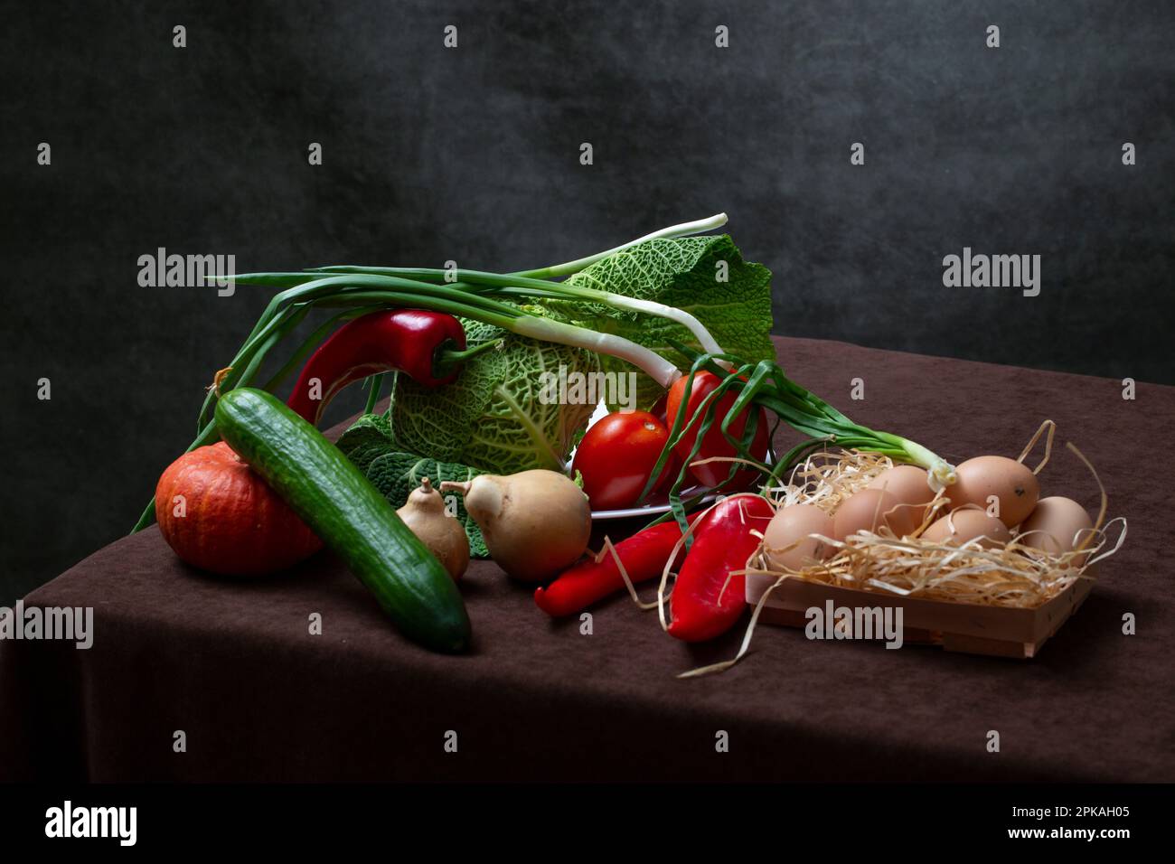 Still life with Savoy cabbage, tomatoes, cucumber, red pepper, pumpkin, onion and eggs Stock Photo
