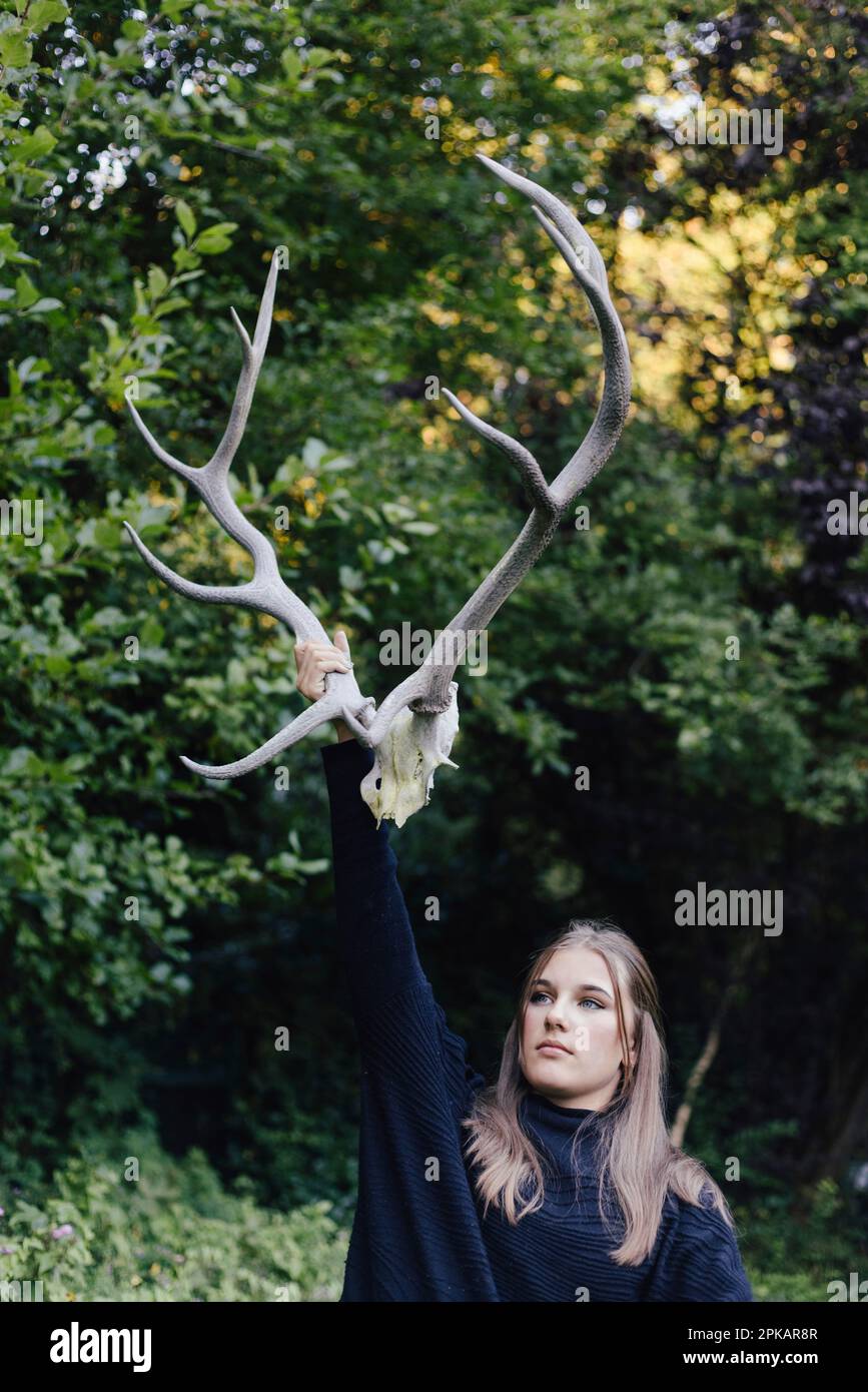 Girl holding a big antlers in the air Stock Photo
