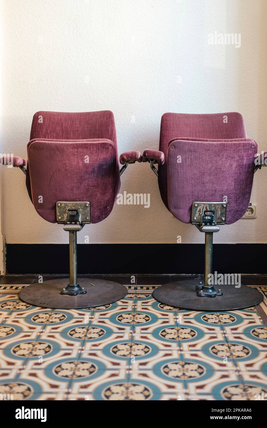 Vintage cinema chairs on an old cement tile floor in old building Stock Photo