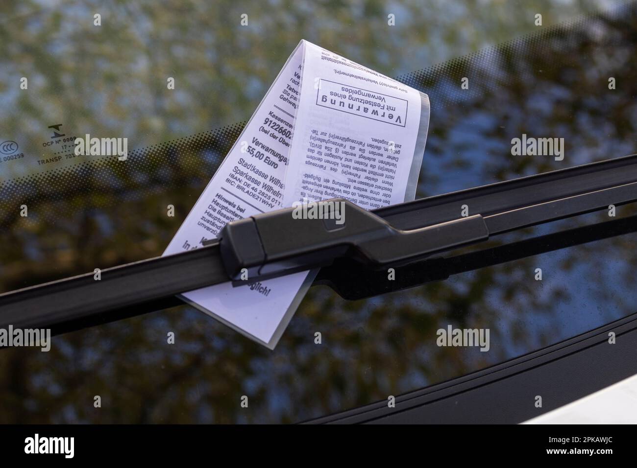 Demand for payment on the windshield of a car, parking ticket for illegal parking on the sidewalk, 55.00 euros, autumn leaves, symbol image, Wilhelmshaven, Lower Saxony, Germany Stock Photo