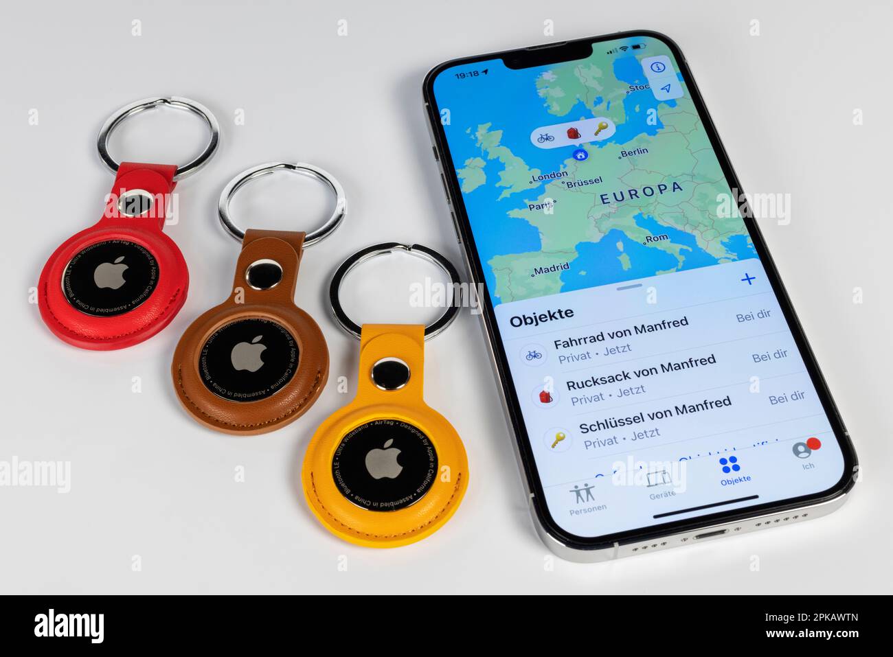 Three AirTag keychains, lying next to iPhone, display, 'Where is?' App