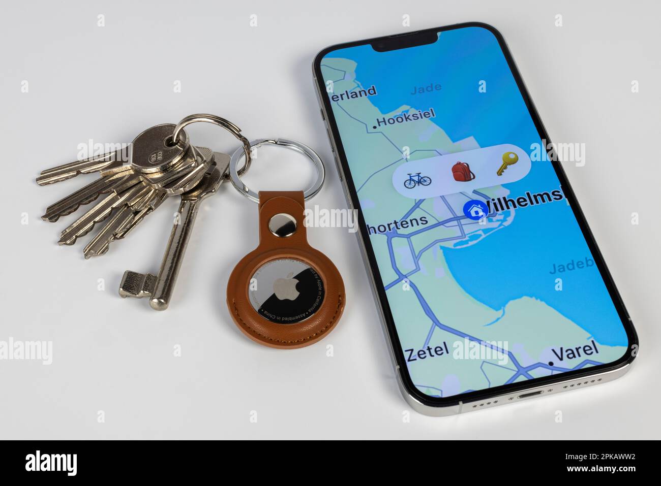 Keychain with brown AirTag keychain lies next to iPhone, display