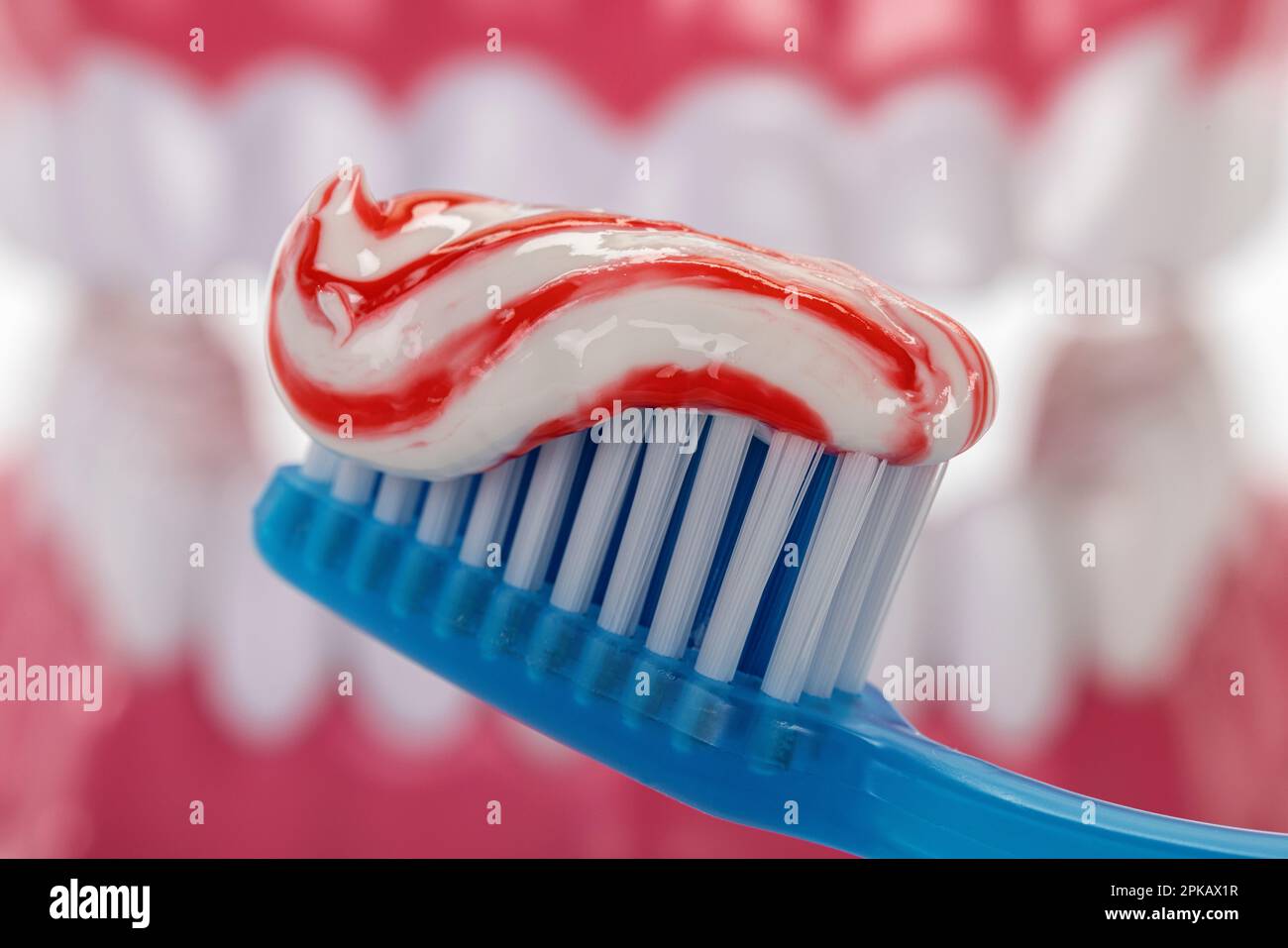 Blue manual toothbrush with toothpaste, brush head, detail, symbol