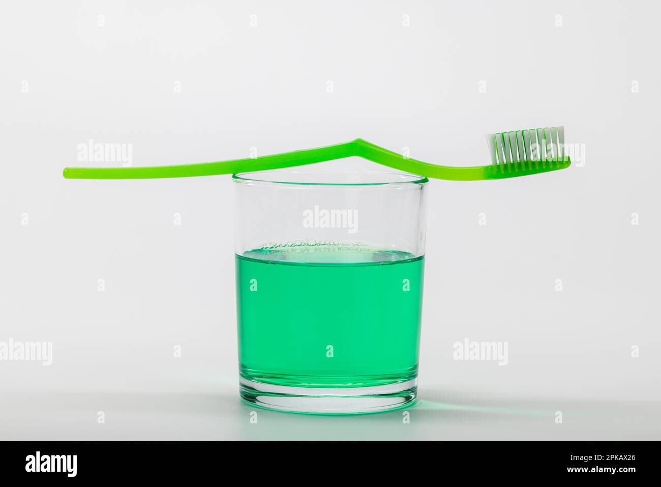 Toothbrush jar filled with mouthwash, manual toothbrush, symbol image