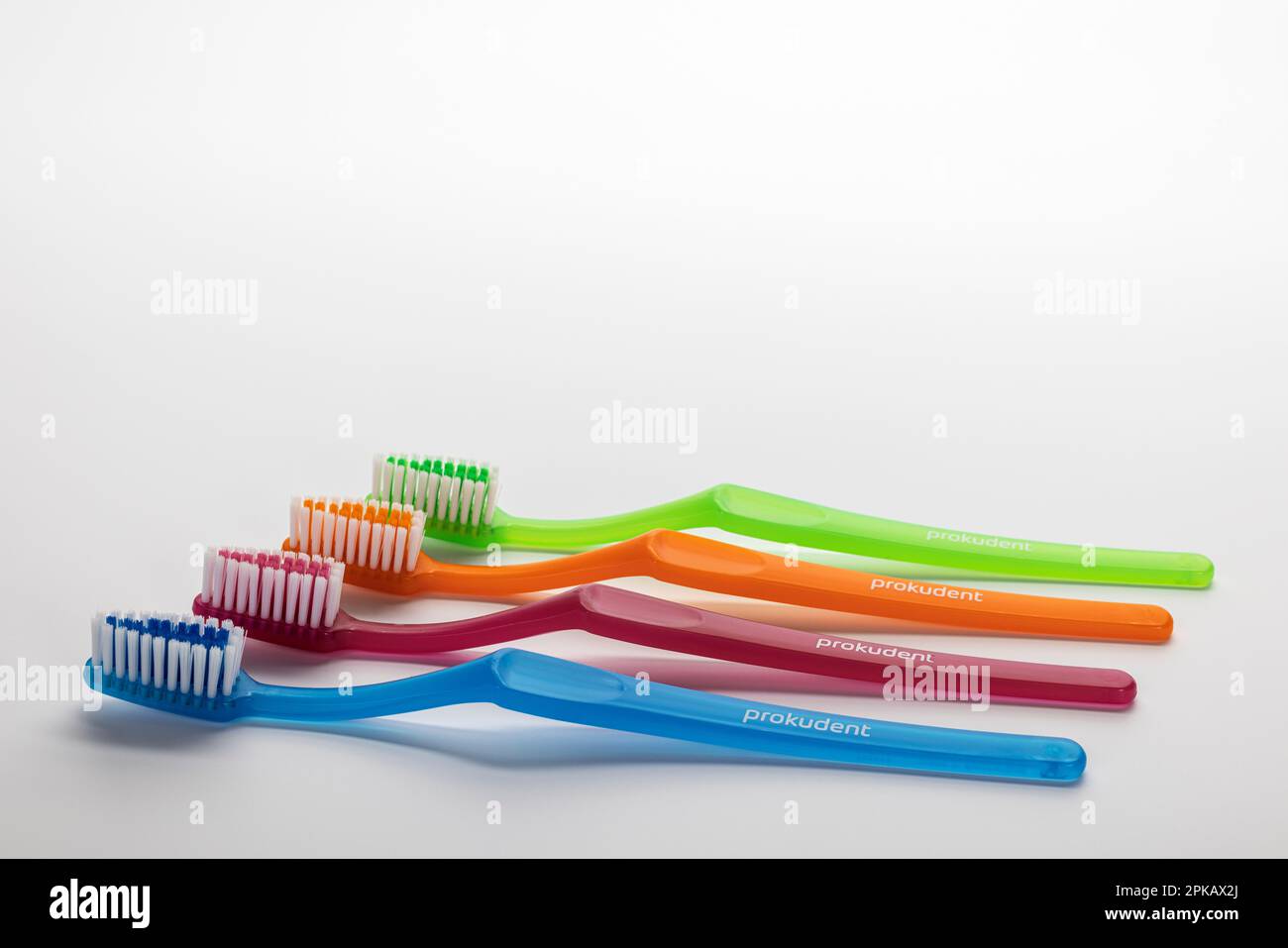 Four different colored manual toothbrushes, white background, symbol