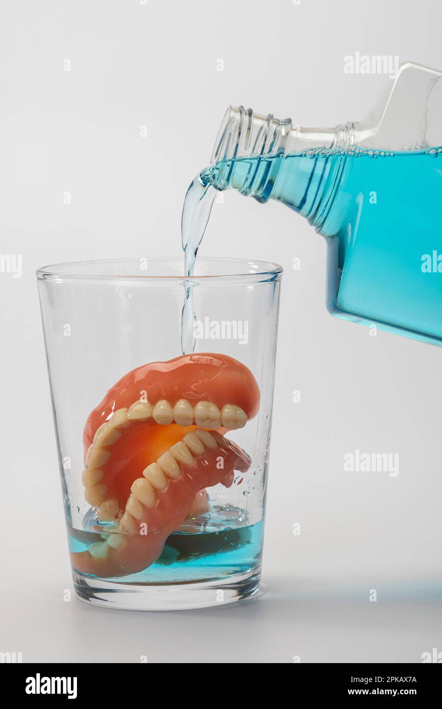 Denture in water glass, cleaning liquid, symbol image, clean dentures