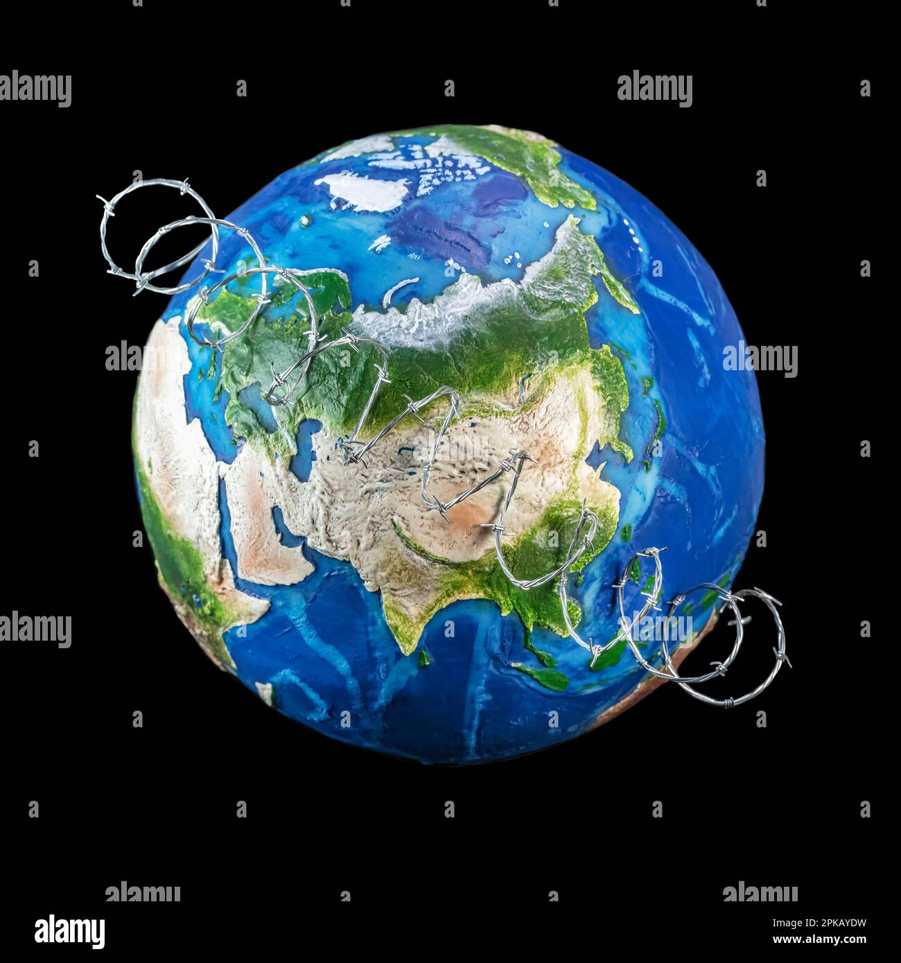 World War concept, toy globe wrapped in barbed wire across Russia and China. Stock Photo