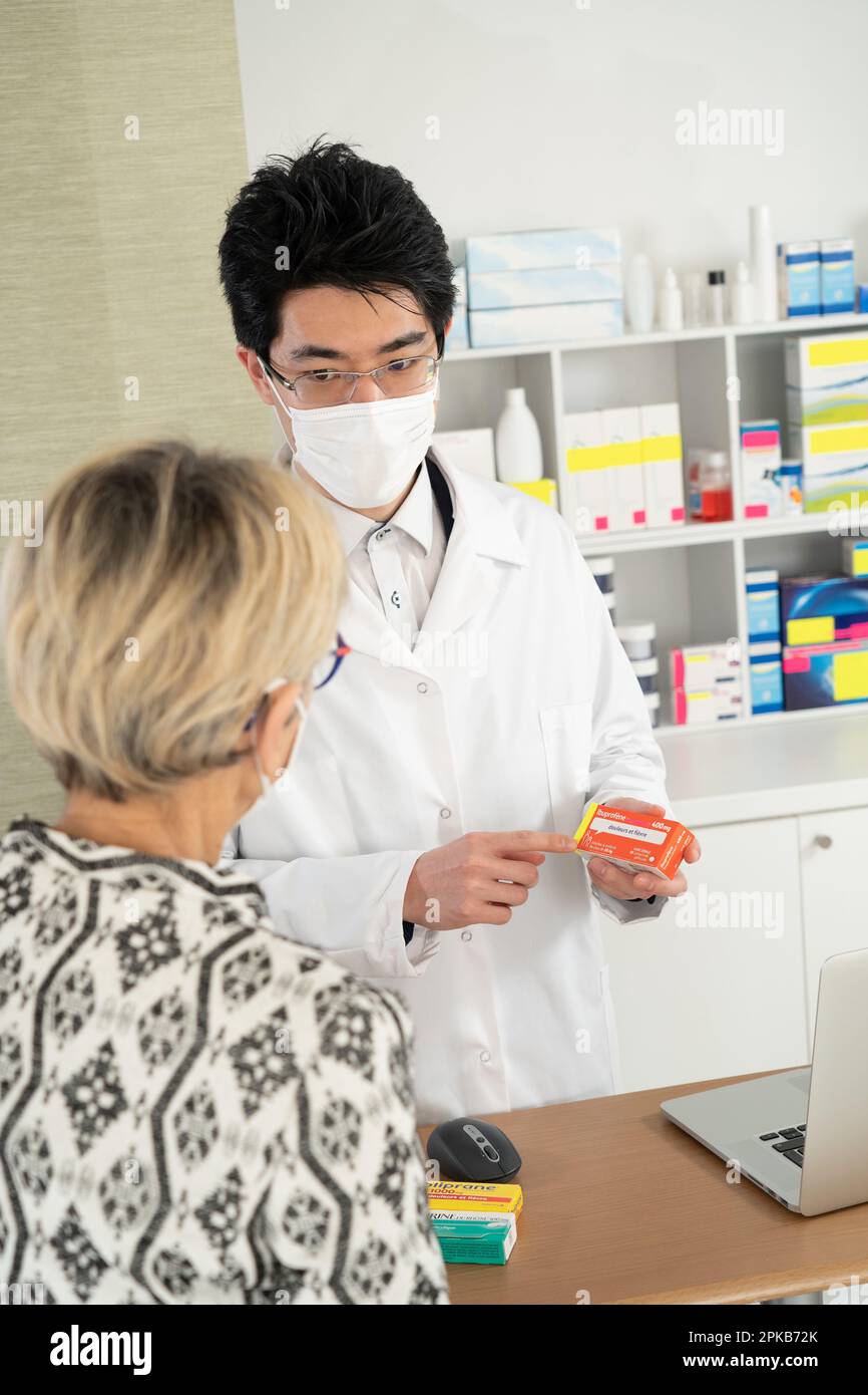 Explanation of a pharmacist on a drug (Ibuprofen) to a client Stock Explanation of a pharmacist on a drug (Ibuprofen) to a client Stock