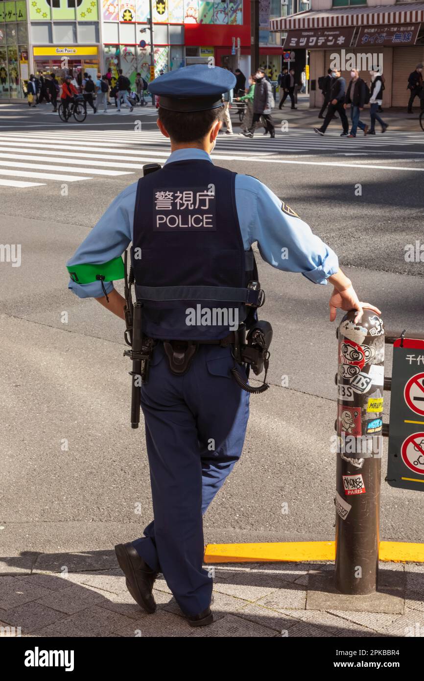 Japan, Honshu, Tokyo, Akihabara, Rear View of Japanese Policeman on Duty Stock Photo