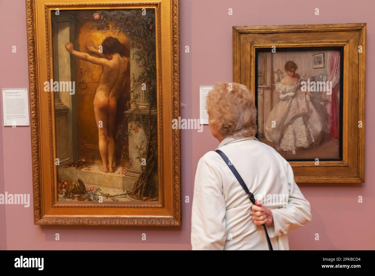 England, Dorset, Bournemouth, Russell Cotes Art Gallery and Museum, Gallery Visitor Standing in front of a copy of Painting titled 'Love Locked Out' dated Henry Justice Ford Stock Photo