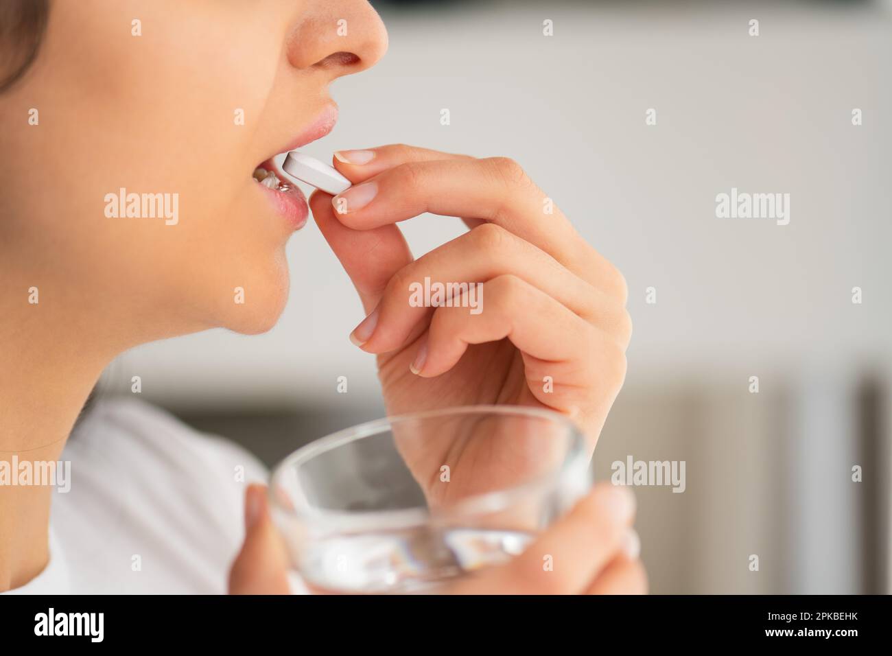 Multiracial young woman ready white pill of calcium with a glass of water in hand, Healthy lifestyle in prevention and treatment of diseases Stock Photo