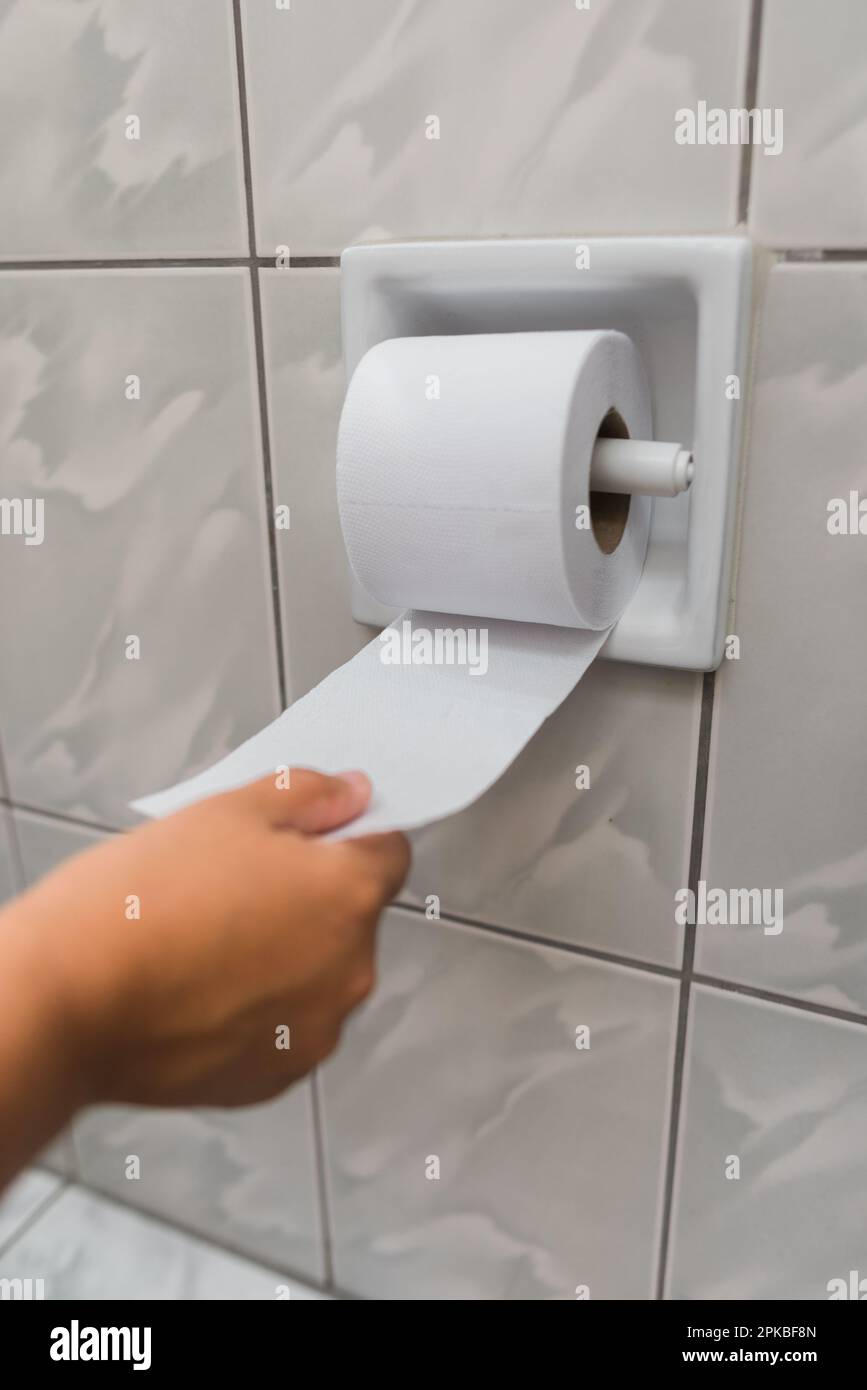 image of a woman's hand unrolling a toilet paper Stock Photo Alamy