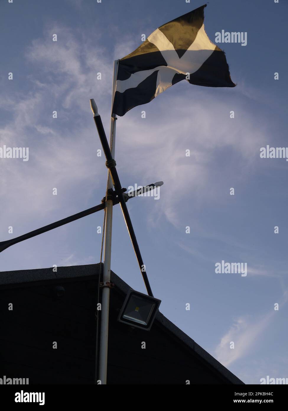 Vertical shot of a Cornish flag flying above Bude Rowing Boats, Bude, Cornwall, UK Stock Photo