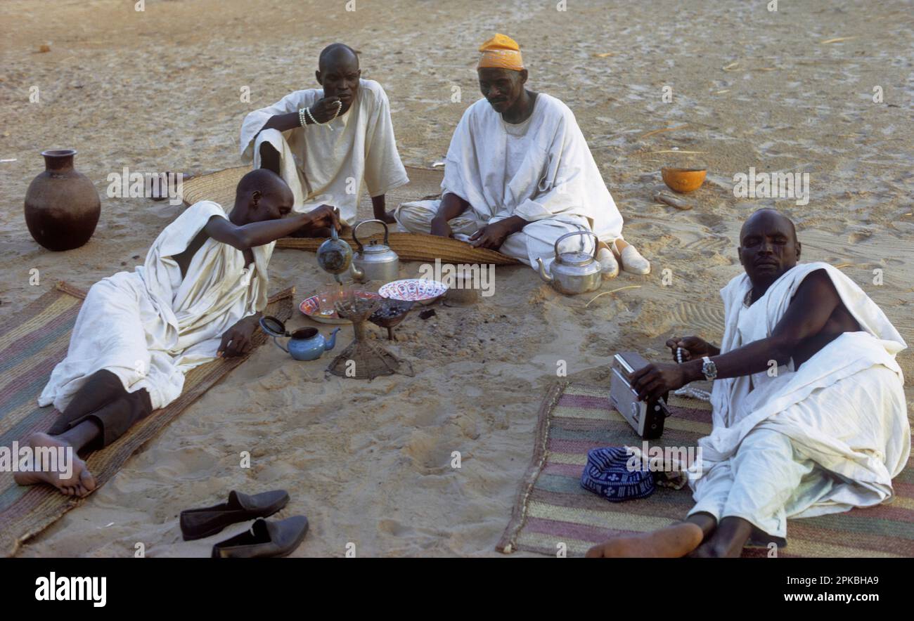 Africa, Sahel region, Chad, islands of Lake Chad, Buduma tribe: men sitting around drinking tea; two men are holding islamic prayer beads. Stock Photo