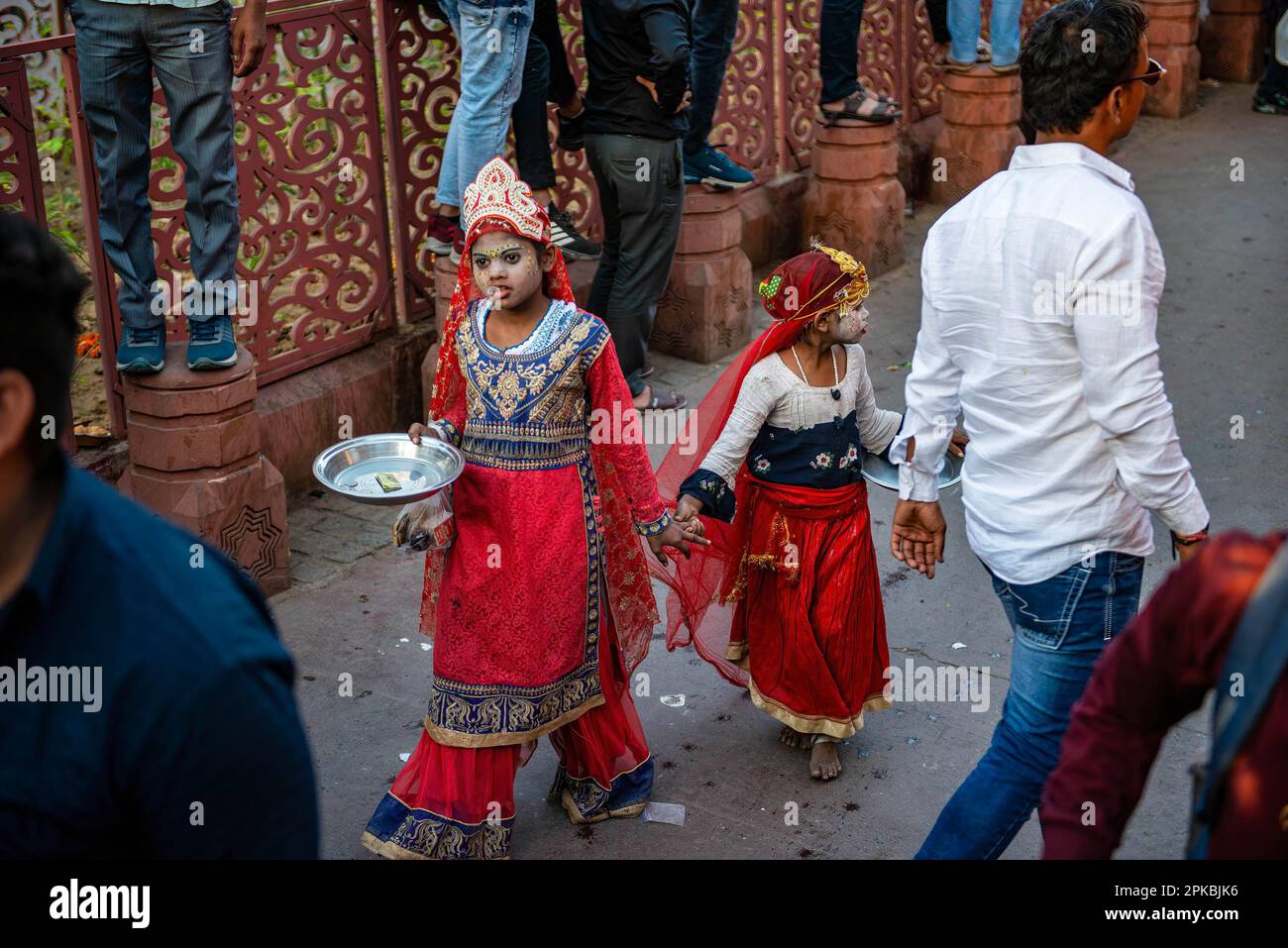 Young girls dressed like Goddess, beg for money during a procession for the Hindu festival Hanuman Jayanti. The festival commemorates the birth of the Hindu deity Hanuman. Stock Photo
