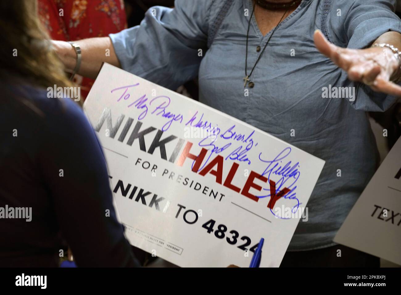 A woman reaches out to hug Nikki Haley after the Republican presidential  candidate autographs a sign for her following a campaign rally on Thursday,  April 6, 2023, in , Gilbert, S.C. (AP