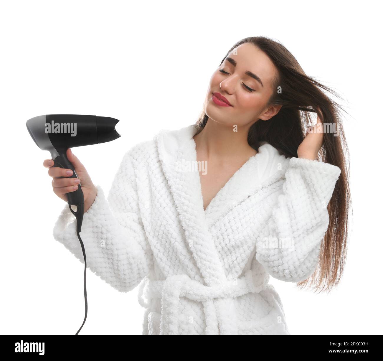 Beautiful young woman using hair dryer on white background Stock Photo ...