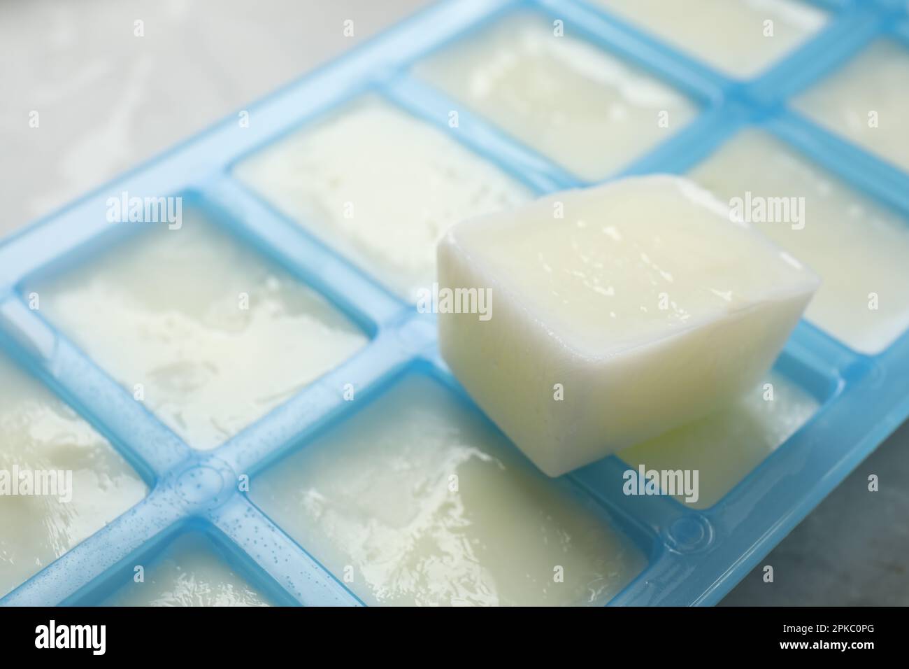 Ice cubes in tray and coffee beans on grey table, closeup Stock Photo -  Alamy