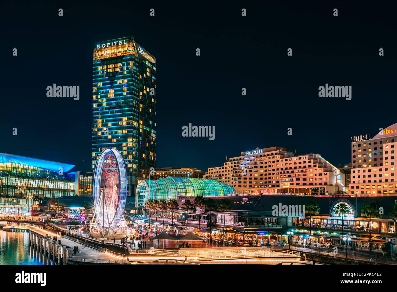 Sydney, Australia - April 16, 2022: Illuminated Sofitel and Novotel hotels viewed across Darling Harbour from Pyrmont Bridge at night time Stock Photo