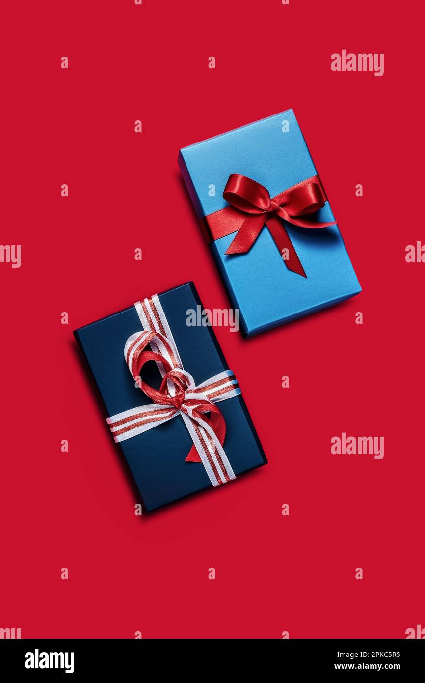 Gift boxes isolated on red background. Two blue gift boxes with bows. View from above Stock Photo