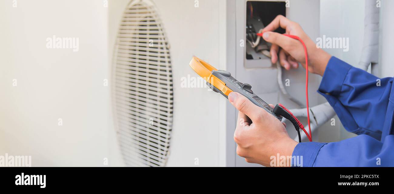 Air conditioner repairman using electricity meter to check air conditioner operation
