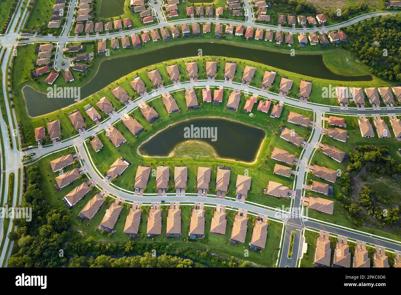 Aerial view of tightly located family houses with retention ponds to