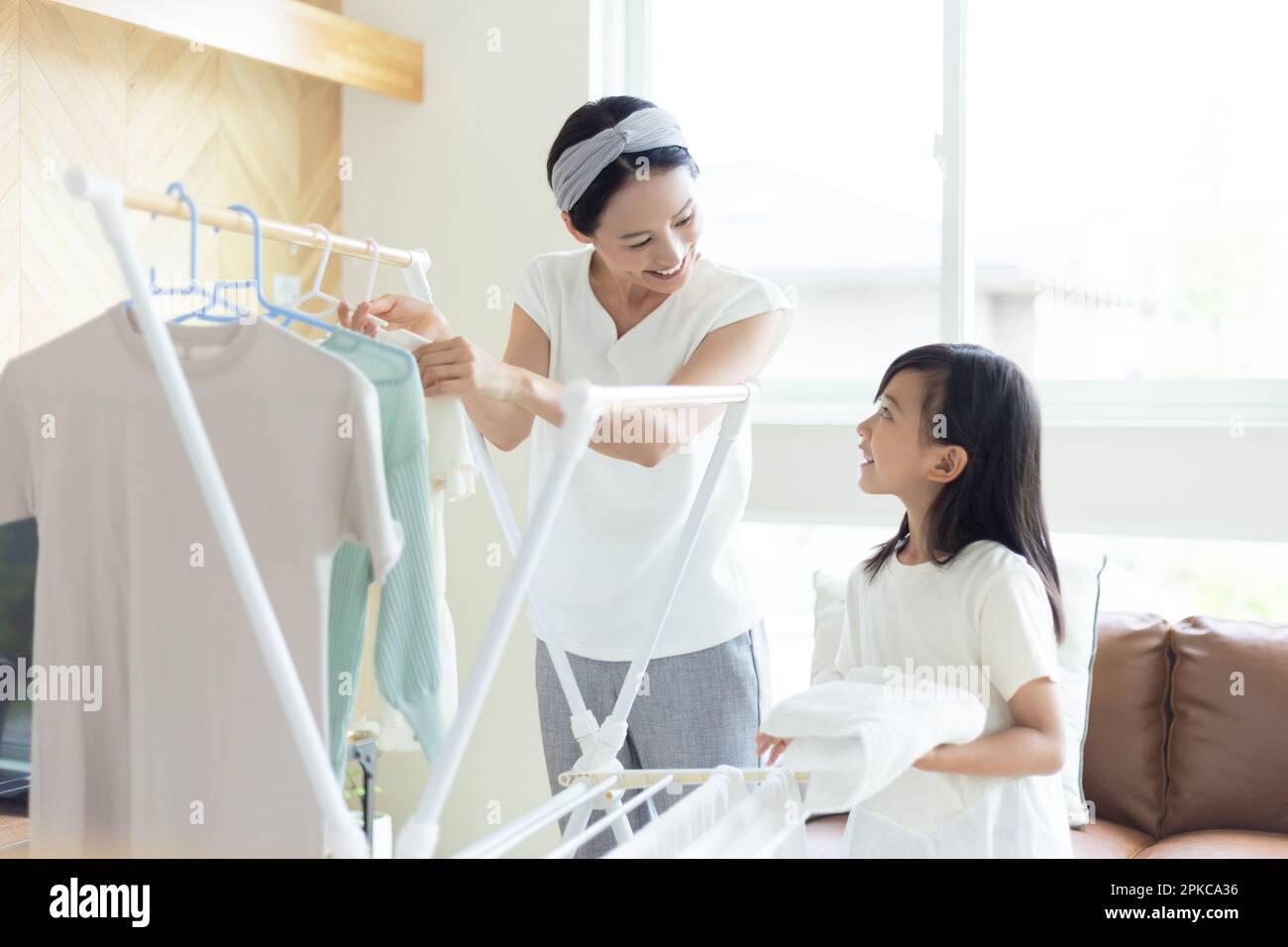 Mother and daughter folding laundry Stock Photo Alamy