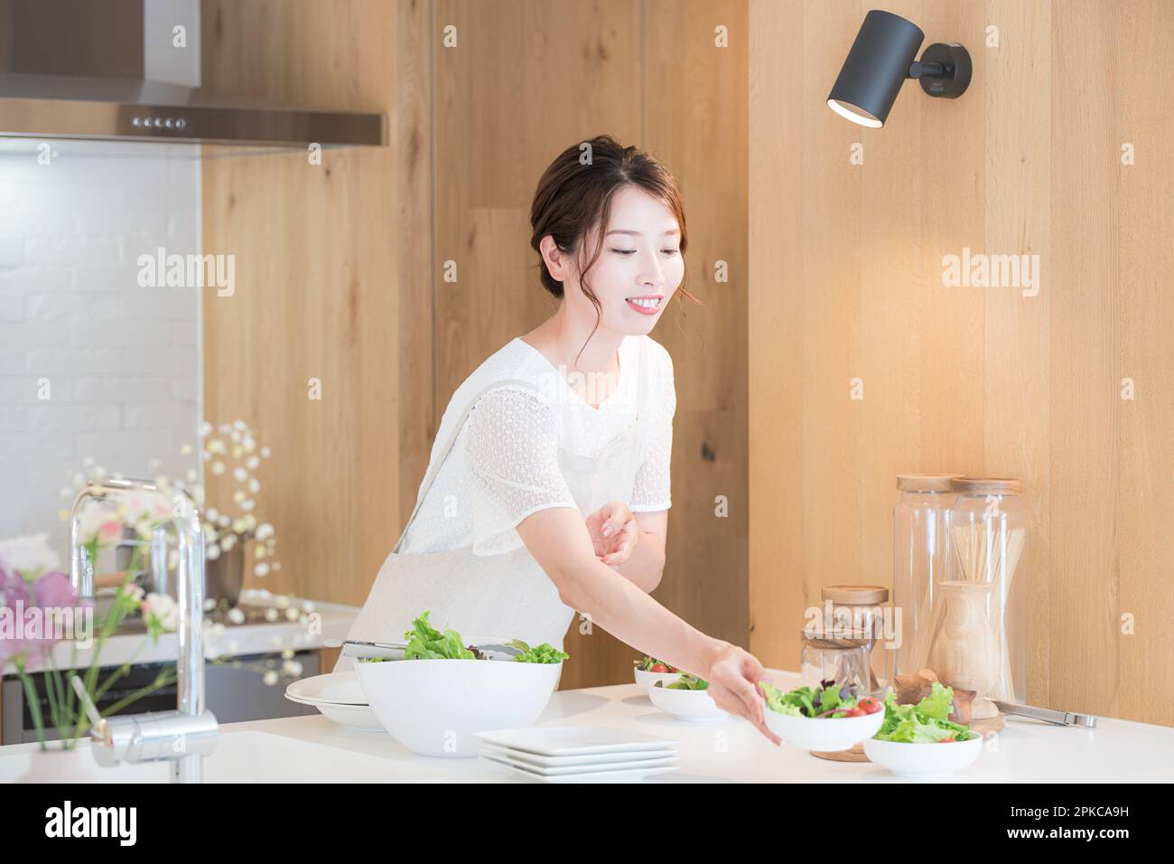 Woman serving a meal in the kitchen Stock Photo