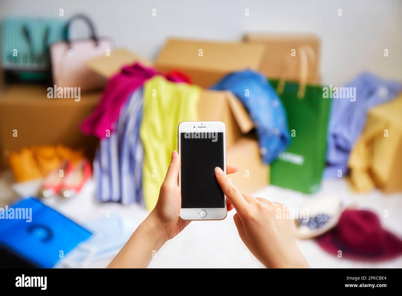 Room cluttered with clothes, hats, etc. coming out of boxes and smart phones Stock Photo