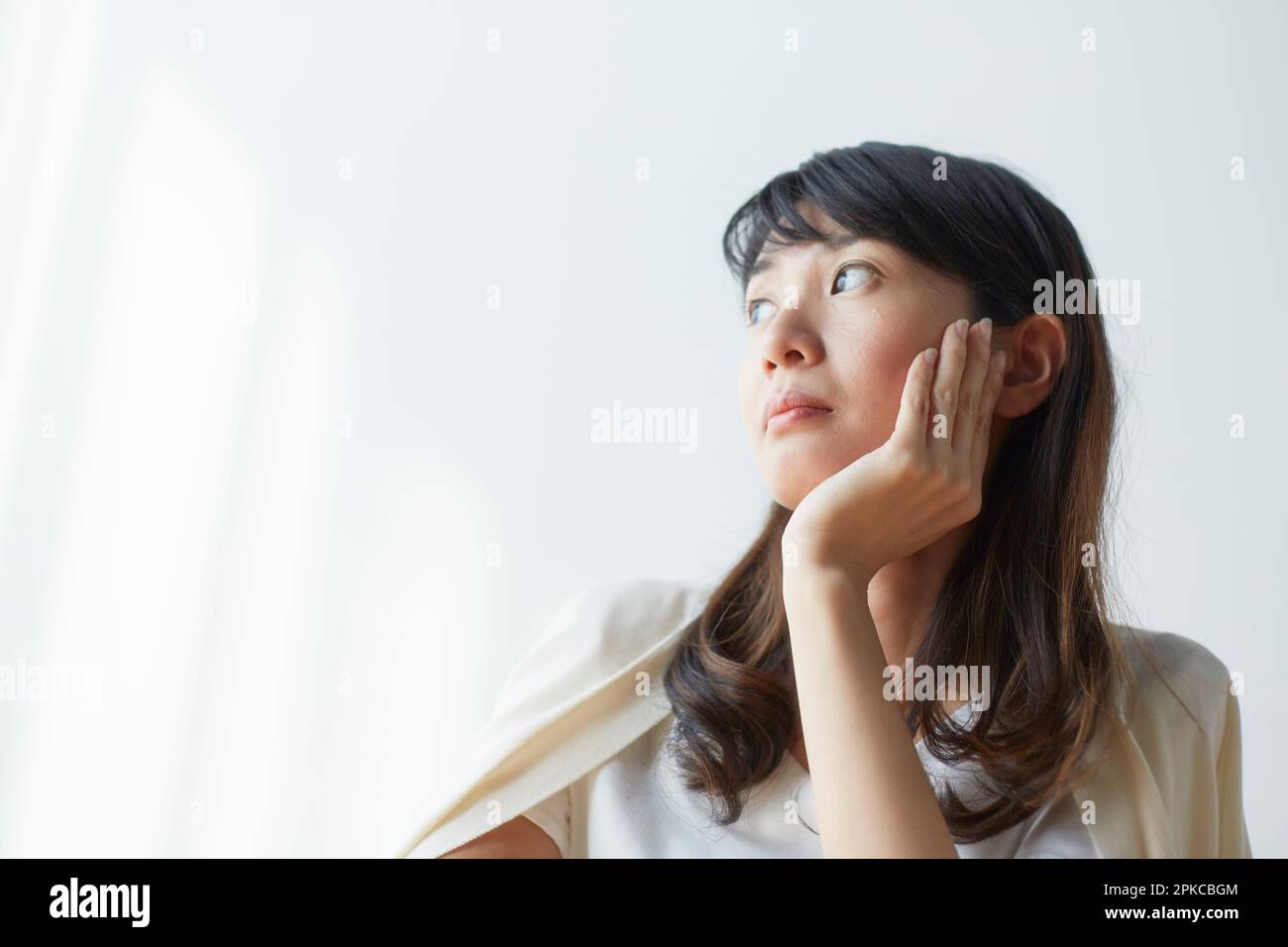 Woman looking out window with cheekbones Stock Photo