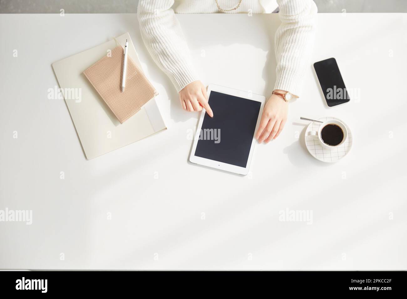 Woman operating tablet while sitting at desk Stock Photo