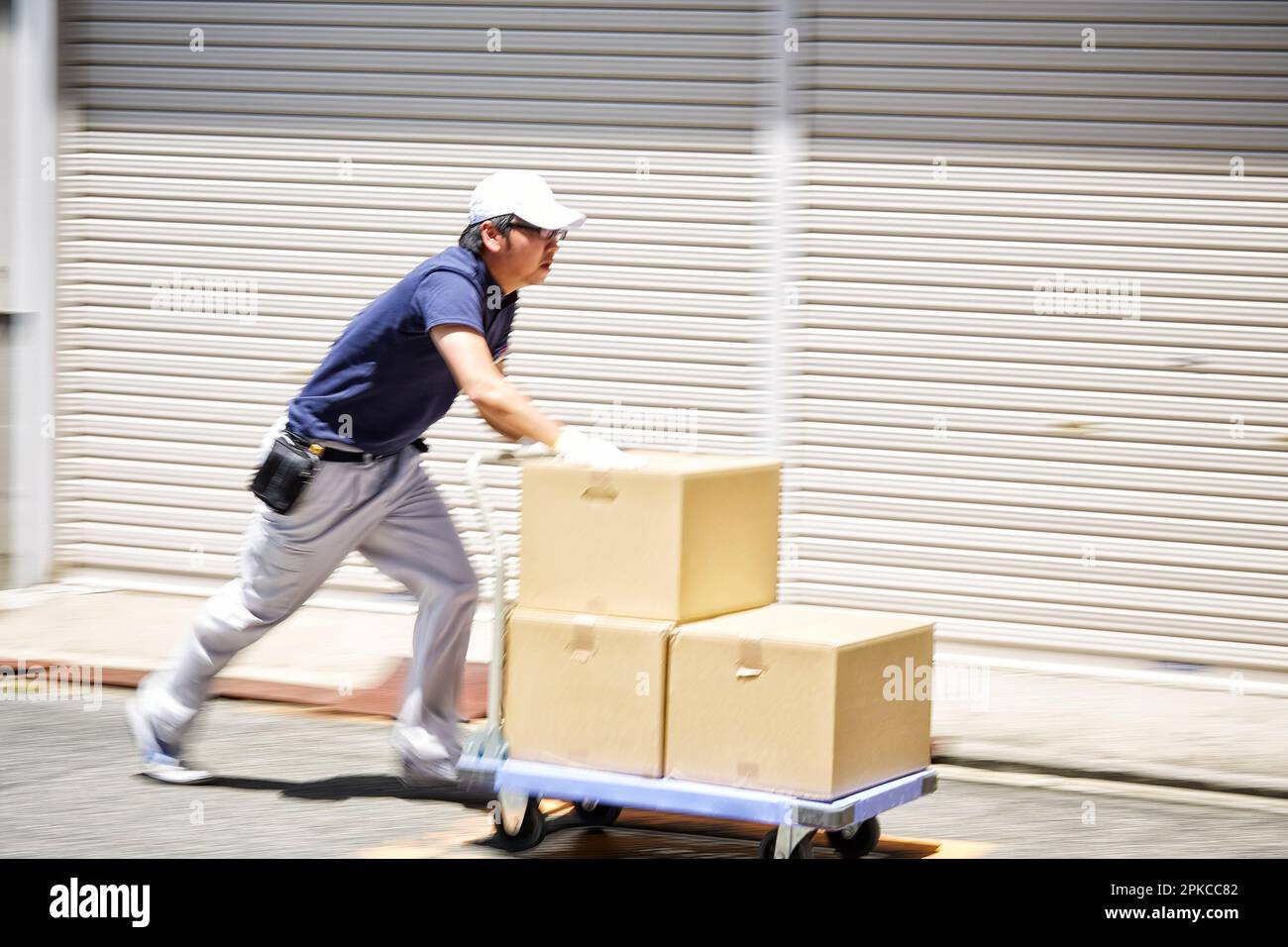 Man carrying cardboard boxes on a cart Stock Photo Alamy