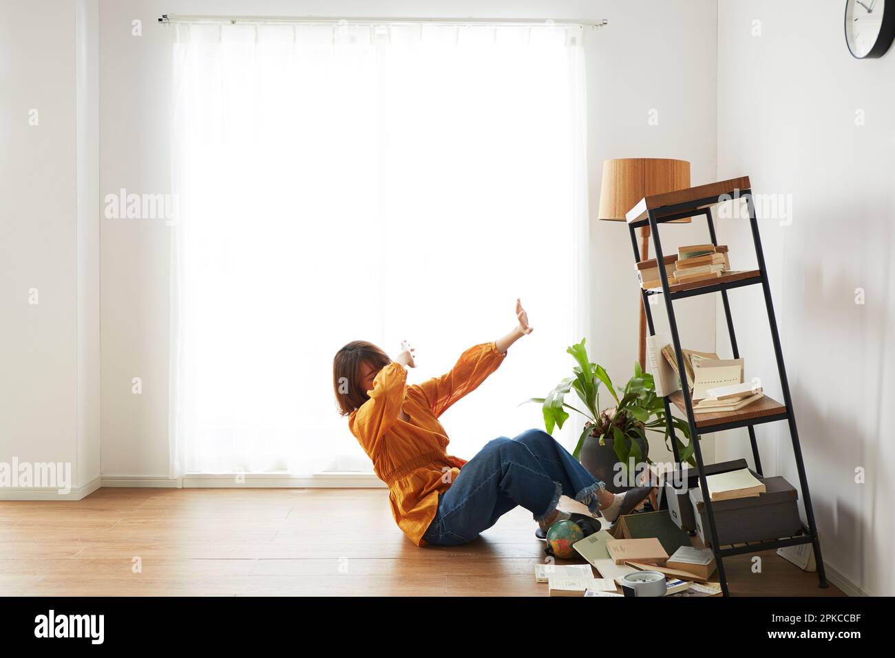 Surprised woman next to a bookcase that collapsed during an earthquake